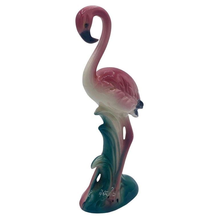 Mid-century California Pottery Ceramic Inquisitive Pink Flamingo Figurine: Mid-century pink and green Inquisitive flamingo ceramic figurine. The statue detailed a pink flamingo with long legs, a slim, tall form standing on a grassy field, with a curious expression. It comes 