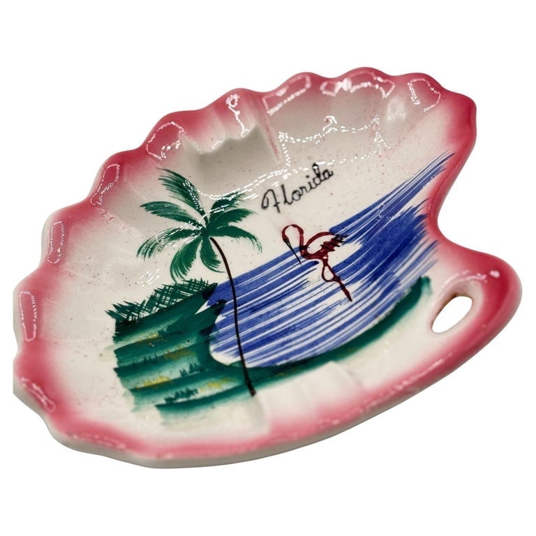 Rare 1940 Biomorphic Pink Flamingo Florida Ceramic Ashtray by Kenmar: Mid-century biomorphic pink and green Florida Pink Flamingo ceramic ashtrays with a flamingo by the shoreline. The ashtray features a beautifully detailed hand-painted scene of a Flamingo on the