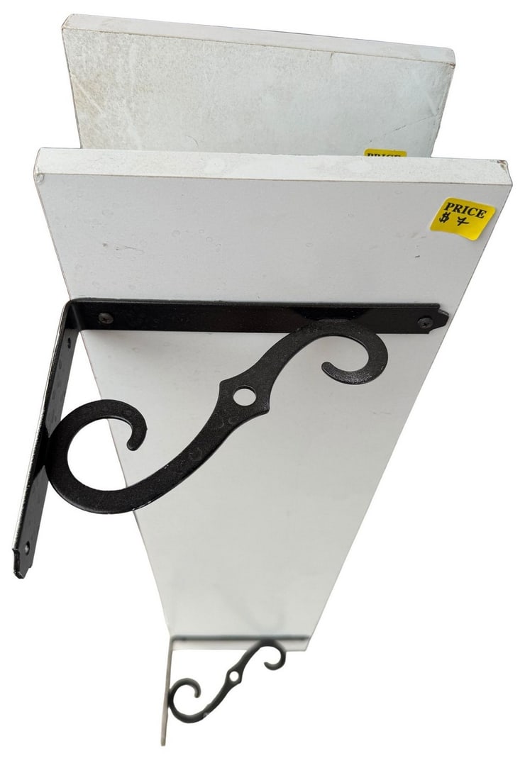 Pair of Decorative Wall Shelves with Wrought Iron Brackets: This lot features a pair of pre-owned decorative wall shelves, each crafted from white-painted wood and supported by two ornate black wrought iron brackets. The brackets display a scrolled design,