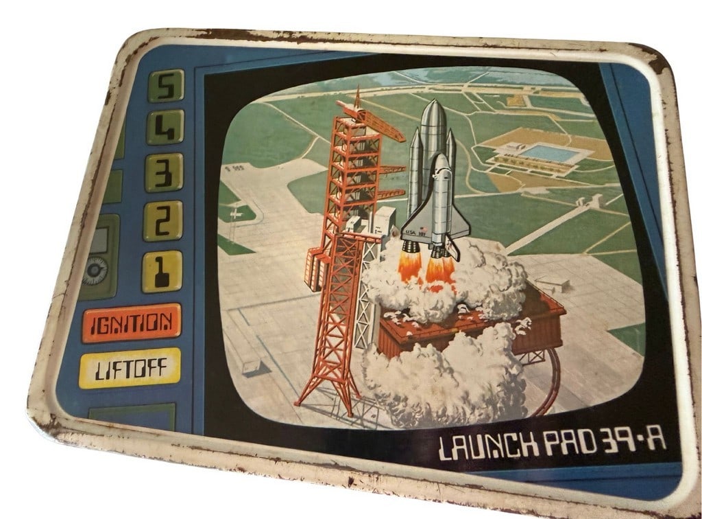 Vintage 1977 Thermos "Asteroid Mining Co." Metal Lunchbox: A vintage 1977 Thermos metal lunchbox featuring a space exploration theme with a Space Shuttle on the "Launch Pad 39-A" side and an "Asteroid Mining Co." motif on the reverse. The lunchbox is made of