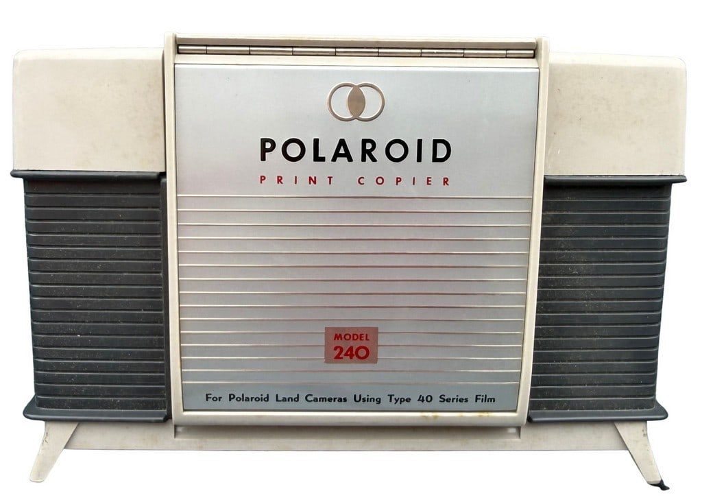 Polaroid Print Copier Model 240: This vintage Polaroid Print Copier, Model 240, is designed for use with Polaroid Land Cameras and Type 40 Series Film. The copier features a cream and dark gray plastic casing with a silver-toned