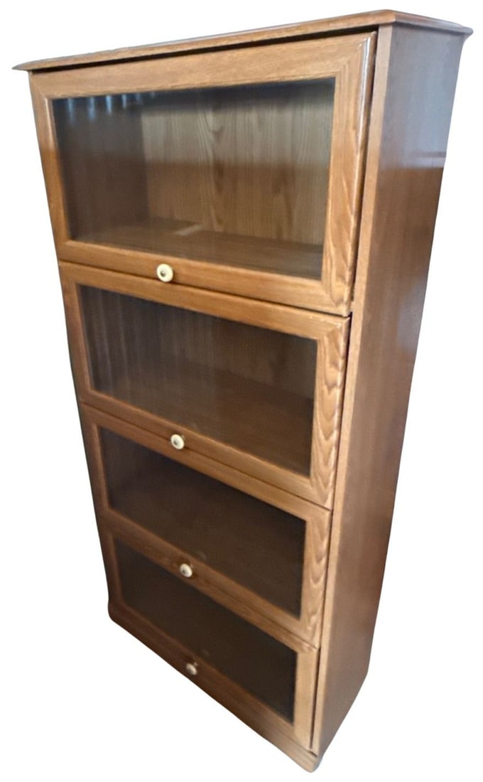 Oak Barrister Bookcases: Two handsome oak barrister bookcases, featuring four stacking sections with hinged glass doors. Each section opens to reveal ample storage space, perfect for books or collectibles. The warm oak finish