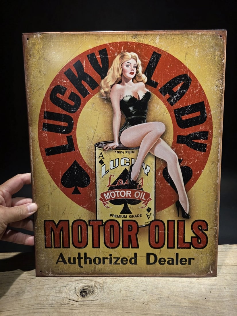 Lucky Lady Motor Oil Tin Pin up Sign: 16" x 12 1/2" Lucky Lady Motor Oil Vintage-Style Tin Sign - Pin-Up Gas & Garage Advertisement Reproduction This vintage-style tin sign is a licensed reproduction of a classic Lucky Lady Motor Oil