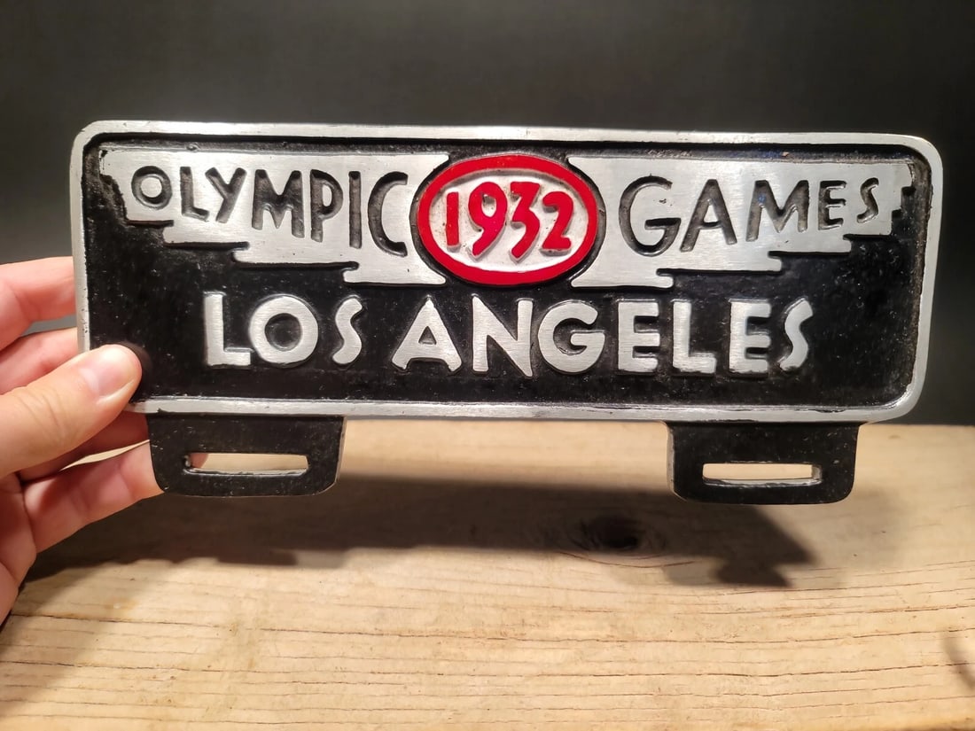 Aluminum Olympic Games 1932 License Plate Fob Topper: 4 3/4" tall x 10 7/8" wide Wonderful reproduction license plate topper. Good detail aluminum, slightly aged to look like an antique. Certainly hard to tell its age. Reserve: $25.00 Shipping: