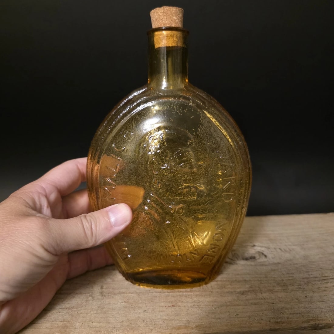 8" Amber Glass Abraham Lincoln Decanter Flask Bottle: Reproduction Amber glass bottle flask featuring an embossed portrait of Abraham Lincoln with patriotic lettering surrounding the image. Bottles of this type are inspired by commemorative historical