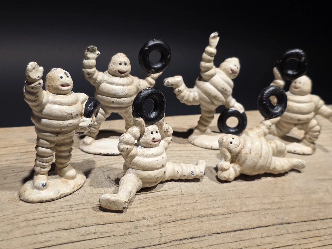 Cast Iron Set of 6 Michelin Men - Classic Advertising: Set of 6 Michelin men, one of the earliest and most recognizable advertising mascots of the 20th century. Rendered here in playful, animated poses, they reflect the lighthearted promotional style