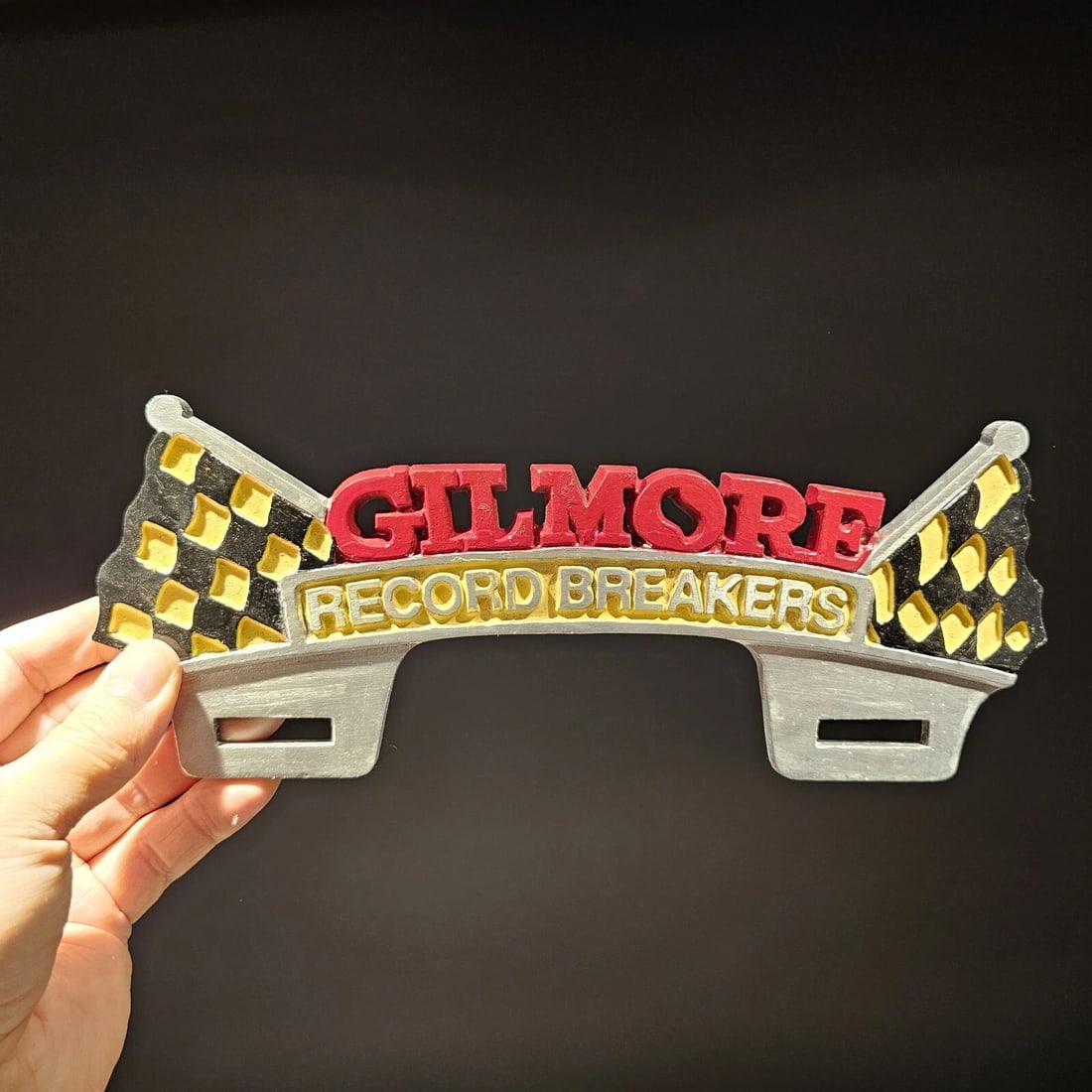 Aluminum Gilmore License Plate Fob Topper: 10 1/2" Wide Wonderful reproduction license plate topper. Good detail aluminum, slightly aged to look like an antique. Certainly hard to tell its age. Reserve: $25.00 Shipping: Domestic: Flat-rate of