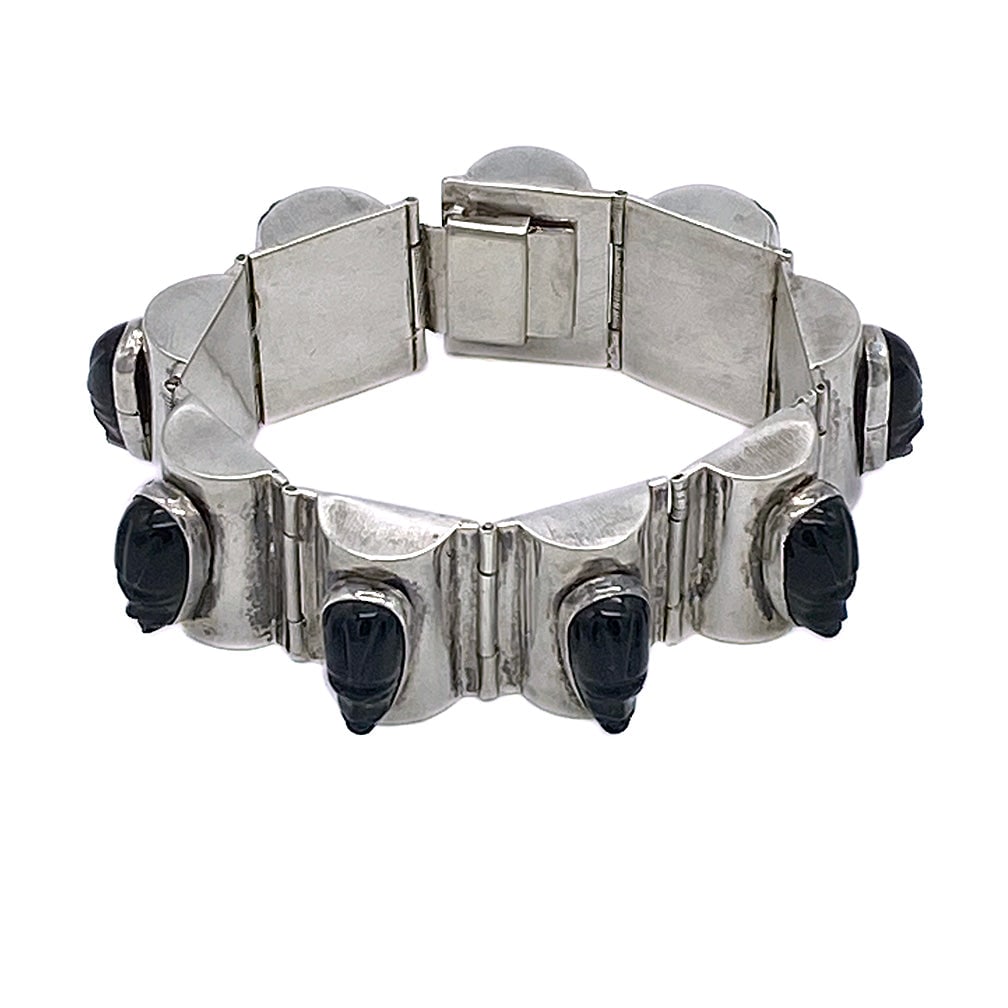 Mexico Silver Bracelet With Aztec Faces: This is a Mexico silver bracelet with Aztec-themed faces. The vintage hinged bracelet weighs 57.6 grams and has nine carved black stone faces and a box clasp stamped Silver Mexico. Probably too tight 