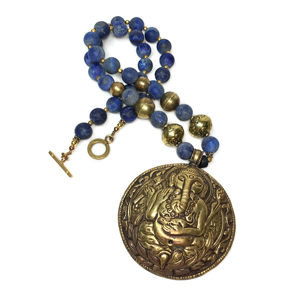 Lapis Lazuli Necklace With Ganesha: This is a Lapis Lazuli necklace with Ganesha pendant. Nouveau Boutique created this long strand necklace with 12 mm matte finish Lapis Lazuli beads, vintage brass spacers, gilt toggle clasp and a Nepa