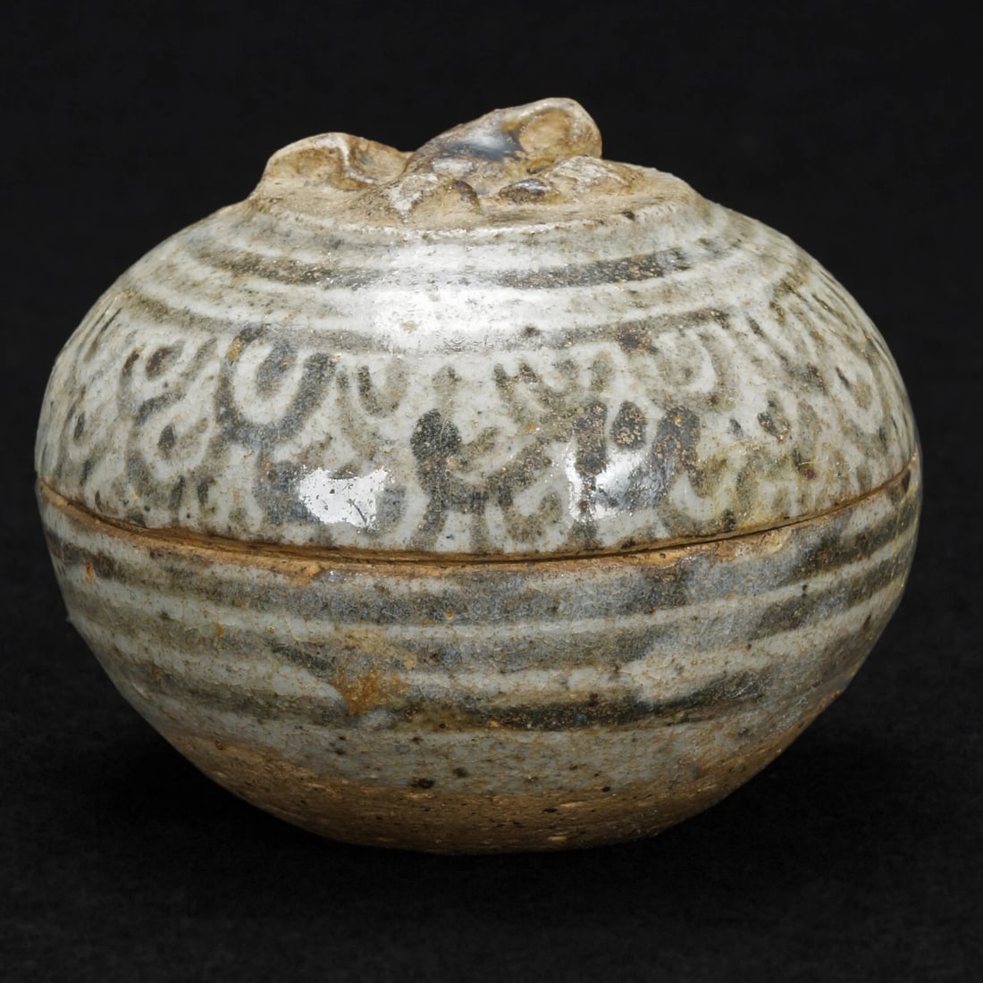 Thai Sawankhalok Stoneware Paste Box 15th C: Title:Thai Sawankhalok Stoneware Paste Box 15th C Size:2 ½ in (6.4 cm) diameter x 2 in (5.1 cm) tall. Description:A very old lidded, round stoneware box with a thin and shiny glaze. It looks