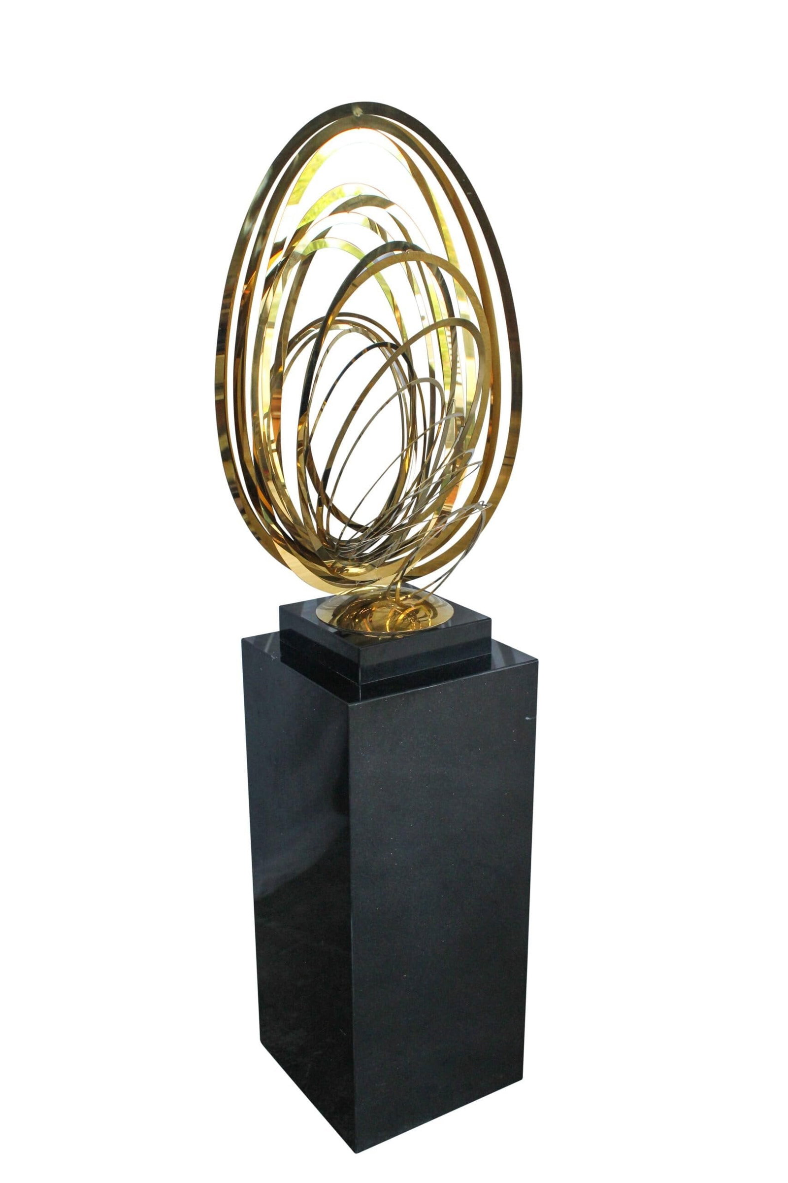 Modern Abstract Brass Sculpture with Black Pedestal Stand 18" x 14" x 67"H: Title:Modern Abstract Brass Sculpture with Black Pedestal Stand 18" x 14" x 67"H Description:This modern abstract sculpture features interlocking brass rings in a striking oval form, mounted on a soli