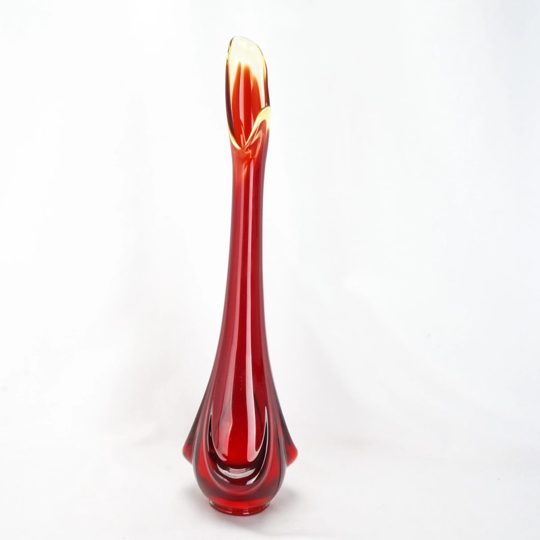 Vintage Amberina 15 in Swung Art Glass Vase: Title:Vintage Amberina 15 in Swung Art Glass Vase Size:14 7/8 in (37.8 cm) tall x 3 3/4 in (9.5 cm) diameter. Description:A pressed glass vase with a design of stretched flames. The glass color goes