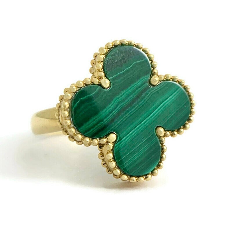 Green Malachite Clover Ring 18K Yellow Gold 6.38 Grams: Green Malachite Clover Ring Gemstones: 1 green clover-shaped malachite Metal: 18K yellow gold Weight: 6.38 grams Stamped: 750, 18K Size: 6.75 (can be sized for a small fee) Width: 17.3 mm at