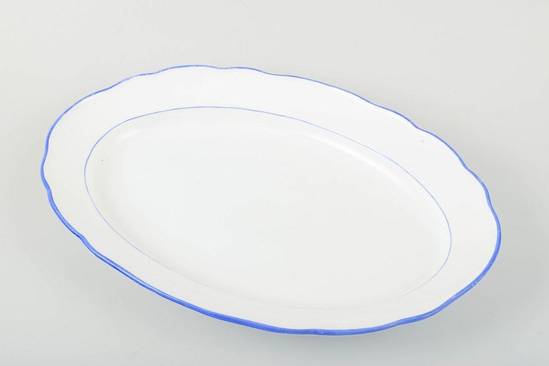 Meissen, Germany. Serving platter in white-glazed porcelain with scalloped rim and blue trim. Circa - 2