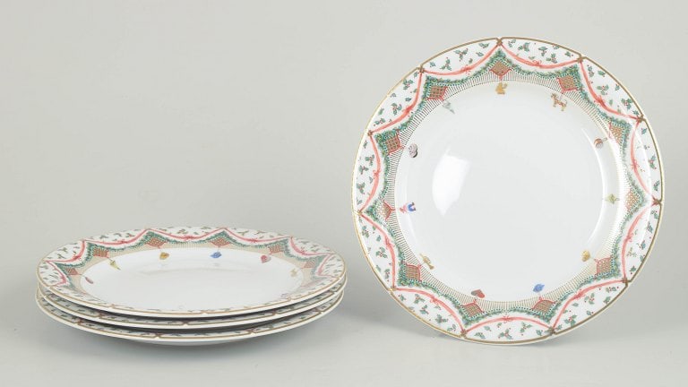 Royal Copenhagen, Denmark. Christmas Joy, set of four porcelain plates with a colourful border.: Royal Copenhagen Christmas Joy, set of four plates. Set of four porcelain plates from Royal Copenhagen in the Christmas Joy pattern, model 622. The plates are decorated with a colourful border featuri