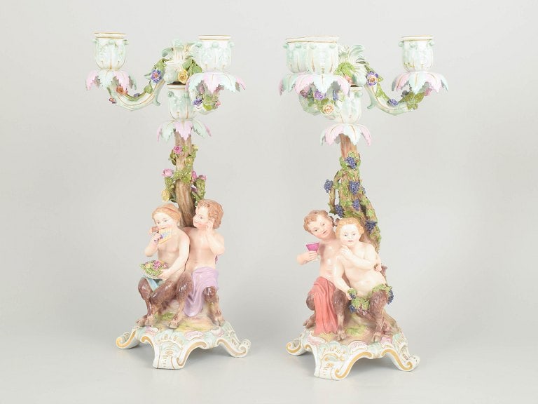 Meissen, Germany. Pair of porcelain three-light candlesticks with tree trunk, floral decoration and: Meissen, pair of three-light candlesticks. Impressive and richly modelled porcelain candlesticks with three arms, designed with a naturalistic tree trunk, floral decoration and figural groups featurin