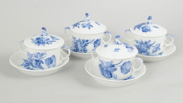 Royal Copenhagen, Denmark. Blue Flower Curved, set of four porcelain bouillon cups with matching: Royal Copenhagen Blue Flower Curved, set of four bouillon cups with matching saucers. Rare set of lidded bouillon cups in porcelain, decorated in the classic hand-painted Blue Flower Curved pattern. M