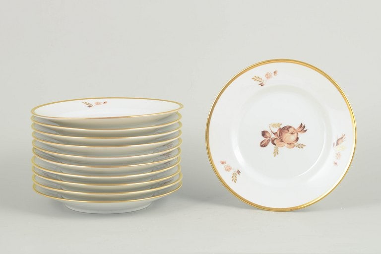 Royal Copenhagen, Denmark. Brown rose, set of eleven porcelain plates with gilded rim. Approx. (1 of 4)