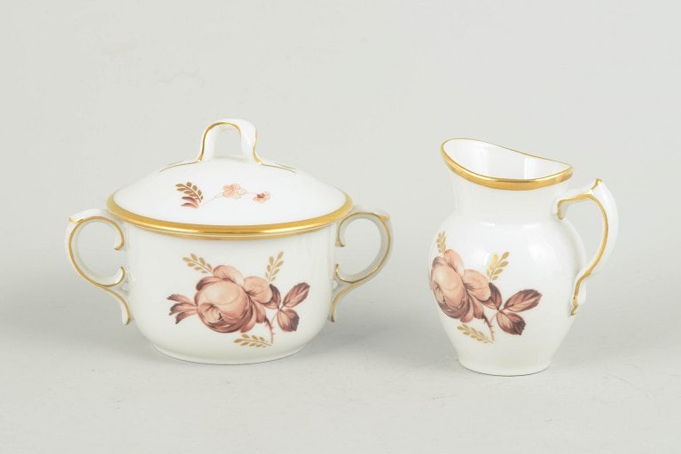 Royal Copenhagen, Denmark. Brown rose, porcelain creamer and sugar bowl with gilded rim. Approx.: Royal Copenhagen brown rose, creamer and sugar bowl. Set consisting of a creamer and sugar bowl in white porcelain with brown floral decoration and gilded rim, models 688/9228 and 688/9116, from the