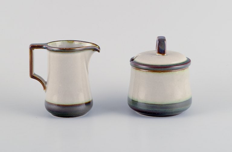 Bing & Grøndahl, , a Tema creamer and a sugar bowl in stoneware.: Bing & Grøndahl, Tema, a creamer and a sugar bowl in stoneware. From the 1970s. Marked. In perfect condition. Creamer: H 10.0 cm. Sugar bowl: H 10.5 cm, including lid. Reserve: $140.00 Shipping: