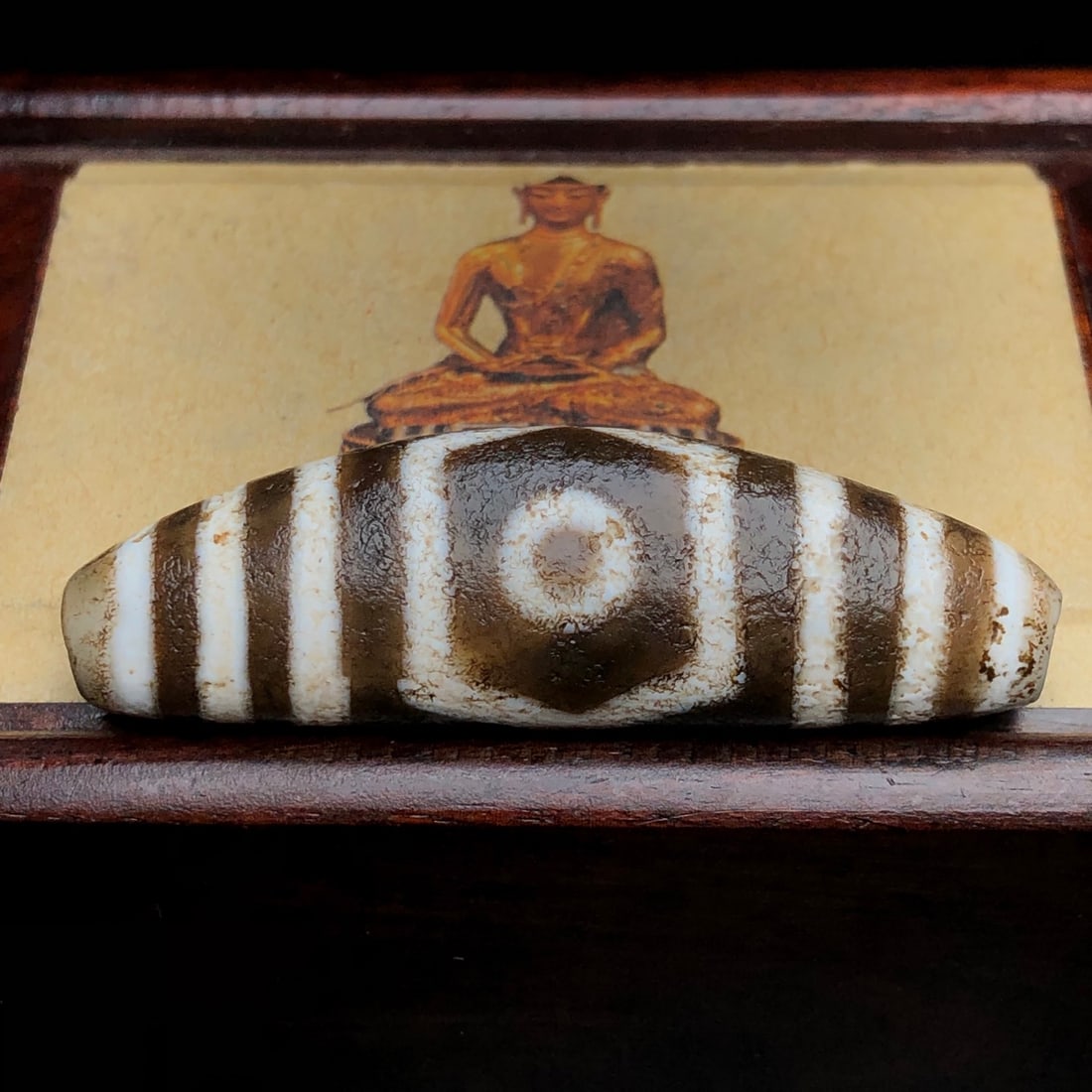 Old Tibetan Three Eyes DZI Agate Pendant: Title: Old Tibetan Three Eyes DZI Agate Pendant Origin: Chinese Date/Period: After1910 Materials: DZI Agate Dimensions: 53x16x12(mm) 2.09x0.63x0.47(inches) Weight 0.03 lbs/15.5g Reserve: $158.00