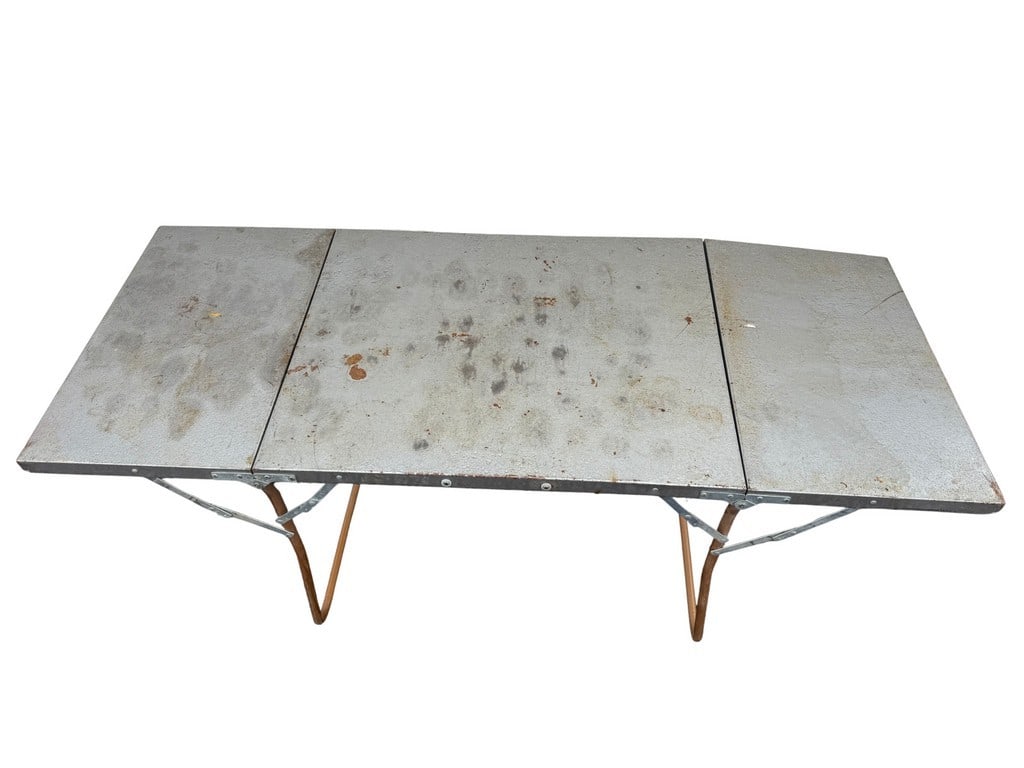 Vintage Military-Style Aluminum Folding Field Table: This vintage field table features a sturdy aluminum top with a three-panel folding design, supported by collapsible metal legs. The top has a utilitarian gray finish, showing significant wear, rust,