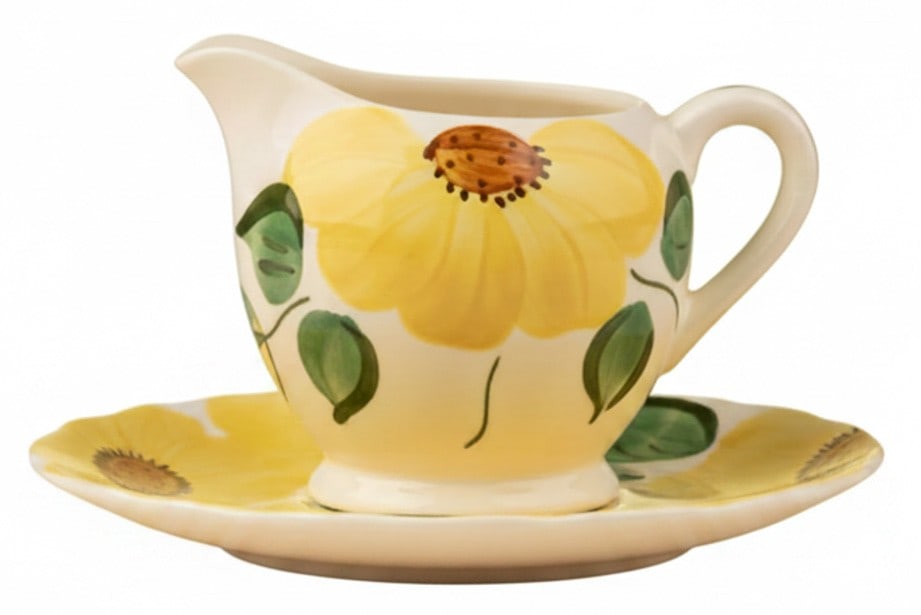 Hand-Painted Ceramic Creamer and Sugar Bowl Set: A charming hand-painted ceramic creamer and sugar bowl set, likely mid-20th century, featuring a vibrant yellow sunflower motif with green leaves on a white ground. The set exhibits a rustic,