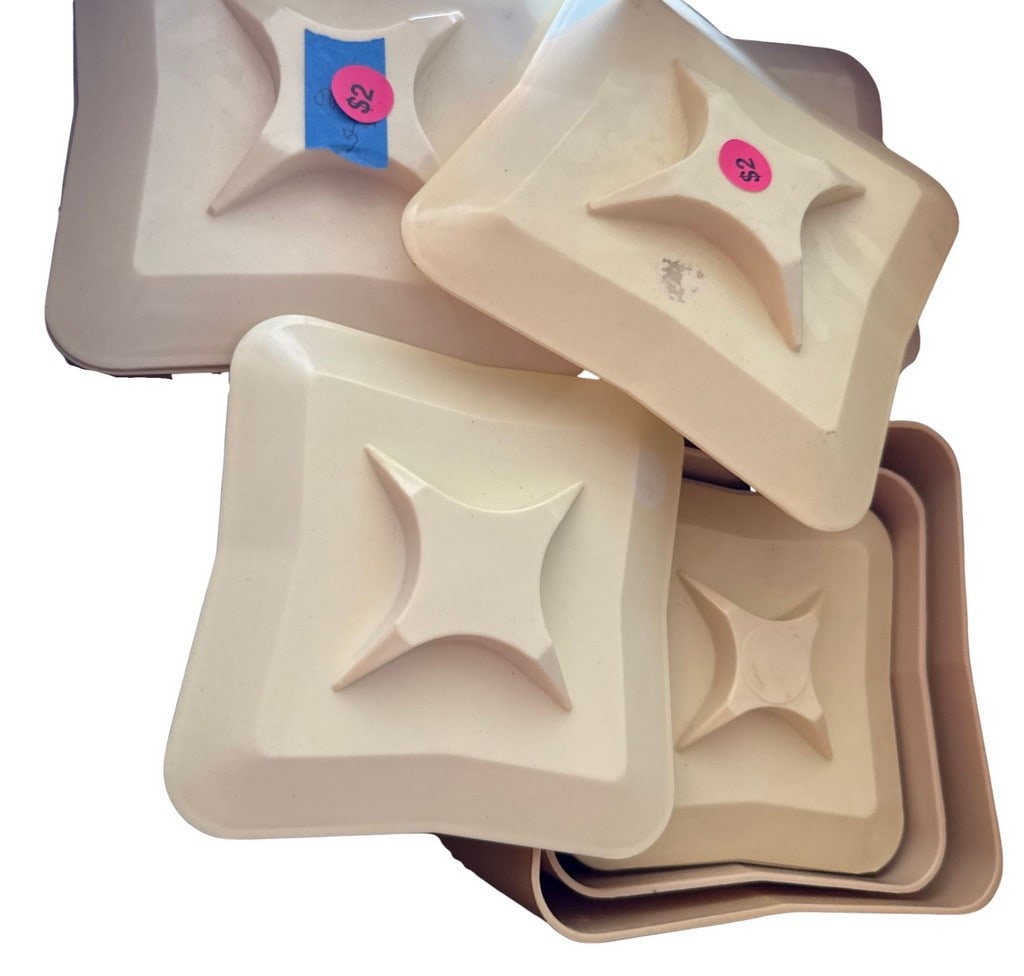 Set of Vintage Mid-Century Modern Stacking Trays: A set of four vintage mid-century modern stacking trays, likely made from thermoset plastic in a cream or off-white color. Each square-shaped tray features a raised, stylized starburst or geometric
