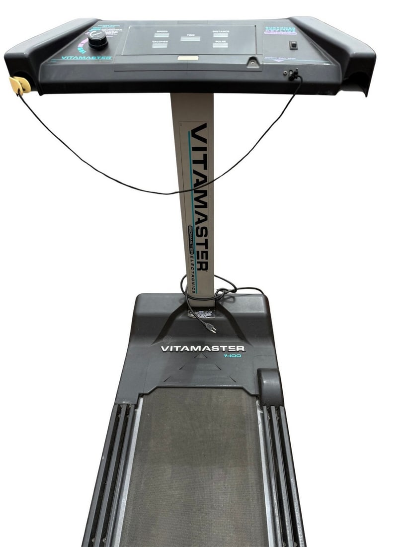 Vitamaster T-400 Treadmill: A Vitamaster T-400 manual treadmill, likely from the late 20th century, featuring a black frame and running belt. The console includes basic controls for speed and distance. It is suitable for