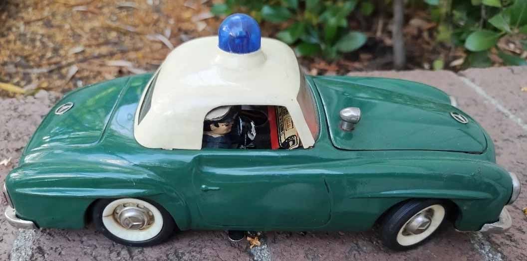 Schuco "Razzia" 5509, Made in Germany, blue light flashes on-off, the policement picks up the - 3