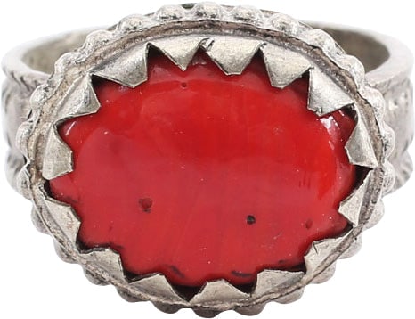 EASTERN EUROPEAN GYPSY WOMAN’S RING, SIZE 8 1/2: 19th century. White metal/base silver. 6.1mm band with raised edges and raised egg and dart medial motif. White metal bezel with hound’s tooth banding and beaded base, set with an oval red