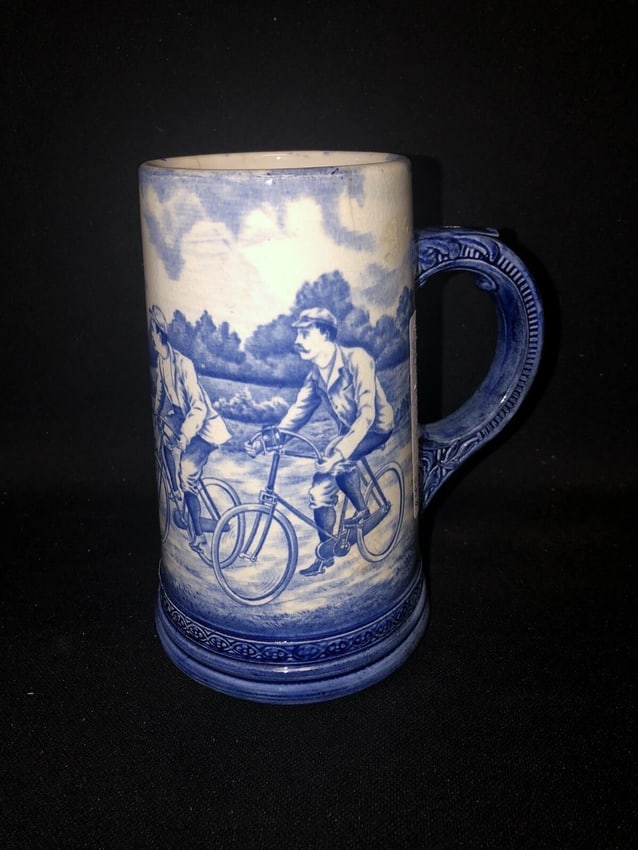 rare royal bonn porcelain bicycle mug: It is 6 7/8" high and is marked. It has a faint 1/2" and two 1" hairlines on the top rim. Otherwise it has no other issues. Bicycle scenes/sporting scenes are rare in royal Bonn porcelain as well as
