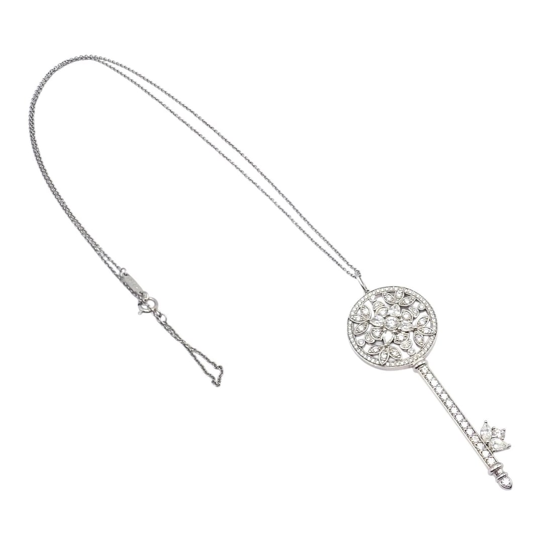 Authentic! Tiffany & Co Platinum Large Victoria Vine Key Pendant Necklace: Crafted in platinum, this Tiffany & Co. Victoria Vine Key pendant necklace features a delicate circular motif adorned with round and marquise diamonds in a floral vine design. The pavé-set key