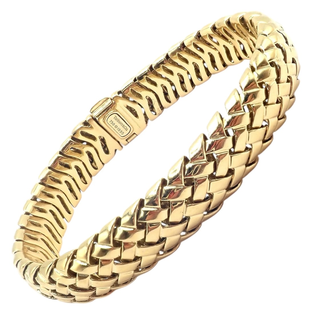 Authentic! Tiffany & Co Vannerie 18k Yellow Gold Basket Weave Bracelet 1995: Elegant Tiffany & Co. Vannerie bracelet from 1995, crafted in luminous 18k yellow gold. The sculptural basket-weave design features fluid, interlocking links that create rich texture and weight. A