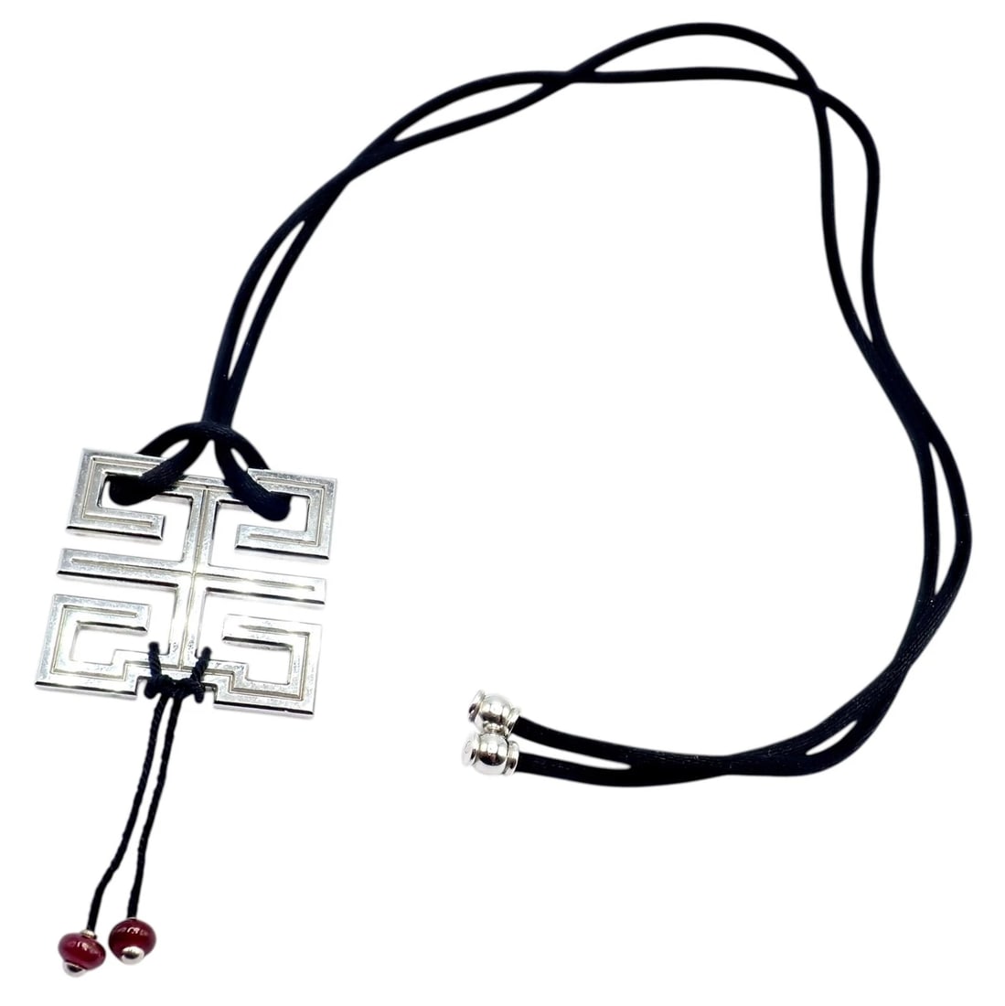 Authentic! Cartier Le Baiser Du Dragon 18k White Gold Ruby Silk Cord Necklace: Striking Cartier Le Baiser du Dragon necklace in 18k white gold, featuring a bold geometric pendant inspired by Eastern motifs. Suspended on a sleek black silk cord, it is accented with rich ruby bead