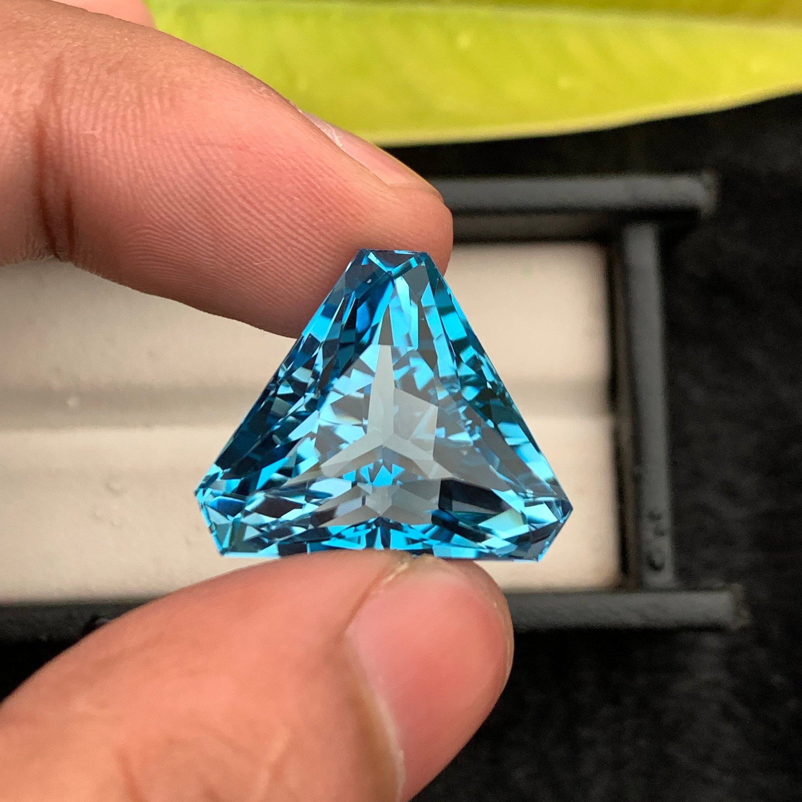 43.25 Carat Swiss Blue Topaz Gemstone: Trillion Cut December Birthstone: Introducing a magnificent Swiss Blue Topaz gemstone. Its fancy trillion shape, which sparkles wonderfully, stands for prosperity and love. This jewel is exquisitely carved and emanates grace and