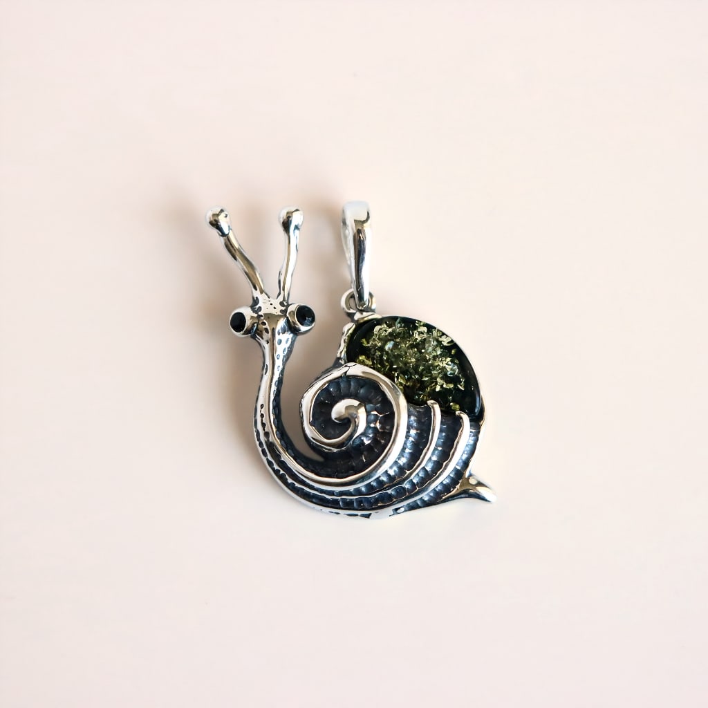 Amber Snail Pendant in Sterling Silver: Title:Amber Snail Pendant in Sterling Silver Description:This amber snail pendant features Baltic green amber set in sterling silver. The amber has a deep green tone with visible internal texture and