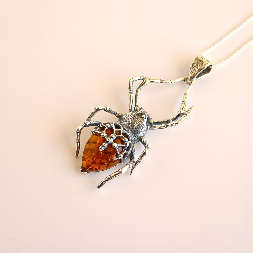 Gothic Spider Pendant: Title:Gothic Spider Pendant Description:This spider amber necklace features a sculptural gothic design crafted in sterling silver and set with Baltic cognac amber. The spider form is detailed with