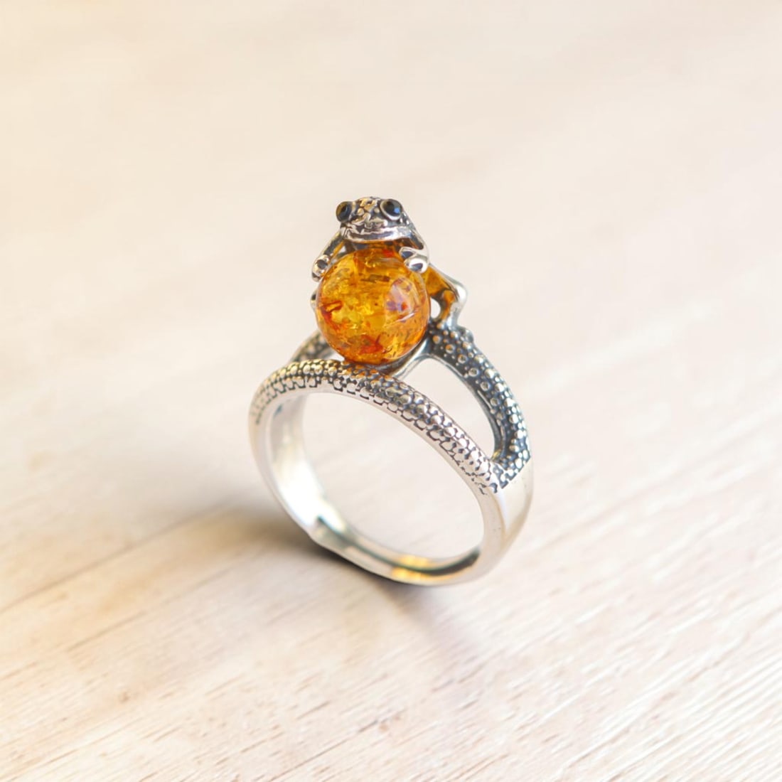 Frog Ring With Baltic Amber in Sterling Silver: Title:Frog Ring With Baltic Amber in Sterling Silver Size:Adjustable Description:This frog ring is made with Baltic amber set in 925 sterling silver. The round amber cabochon has golden honey and