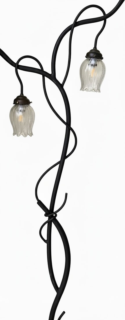 Twisted Vine Motif Two-Light Floor Lamp: A whimsical floor lamp featuring a black metal frame sculpted to resemble twisted vines, supporting two upward-facing lights with fluted glass shades. The design evokes a natural, rustic, or perhaps A