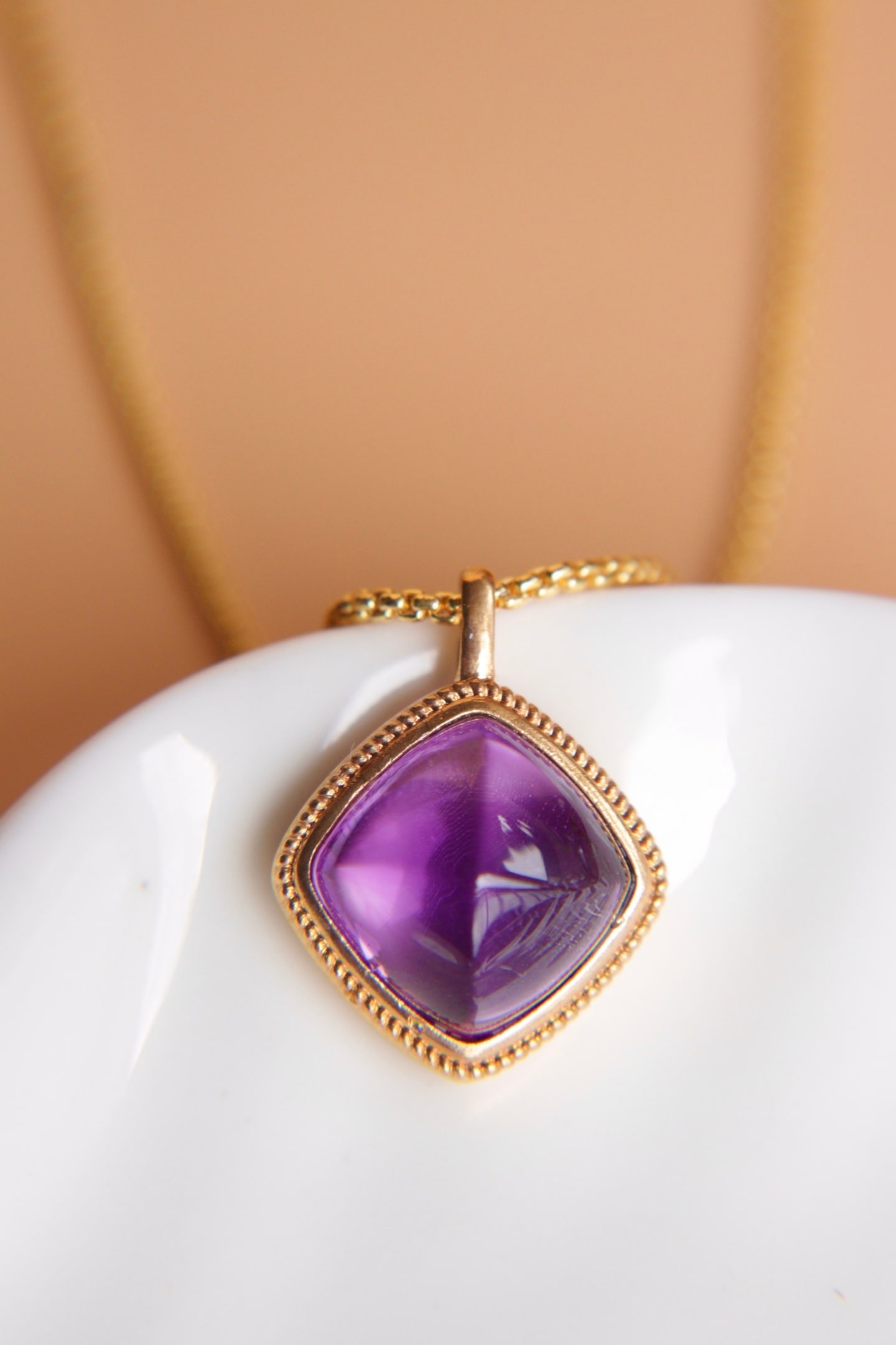 18K Gold Natural Amethyst Pendant: Title: 18K Gold Natural Amethyst Pendant Description: This pendant is meticulously set in 18K gold, featuring an enchanting amethyst with a flawless crystal. Suitable for various occasions, it exudes 