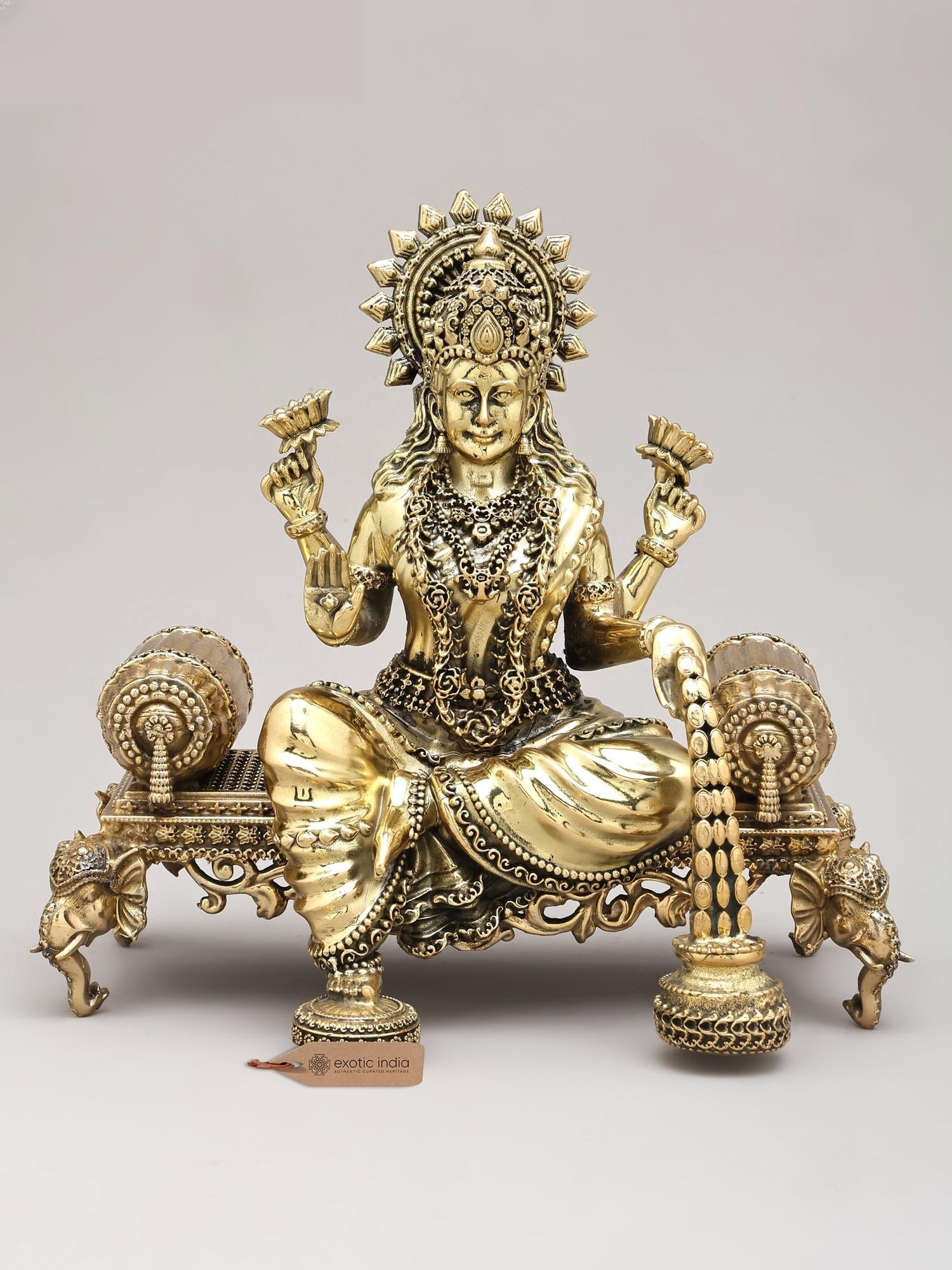 8" Four Armed Goddess Dhanalakshmi Seated on Singhasan | Brass Sculpture: Description: 8" Four Armed Goddess Dhanalakshmi Seated on Singhasan | Brass Sculpture