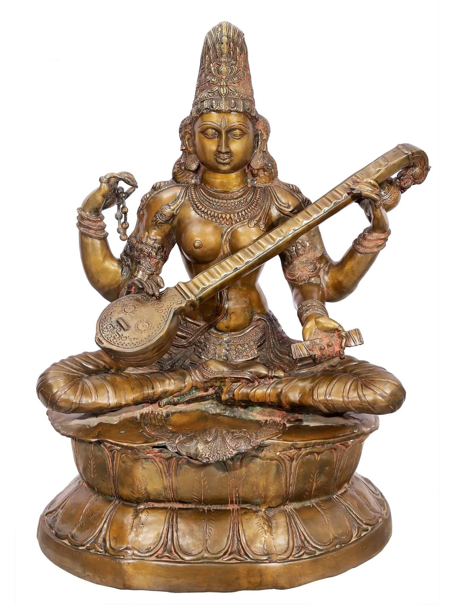 34" Large Kamalasana Saraswati Seated on Lotus | Handcrafted Brass Statue: Description: A unique blend of two iconographic traditions of her image, this brass statue represents four-armed Saraswati, the goddess of learning, literature, arts, music and creative faculties of m