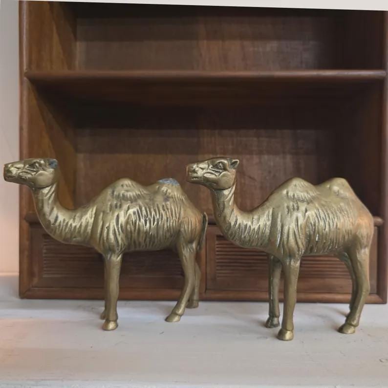 Vintage Solid Brass Camel Pair Sculptural Global Accents Organic Patina Decor: A sculptural pair of solid brass camels featuring warm organic patina and beautiful mid‑century shaping. Their expressive silhouettes and aged brass finish bring a collected, global‑luxe f