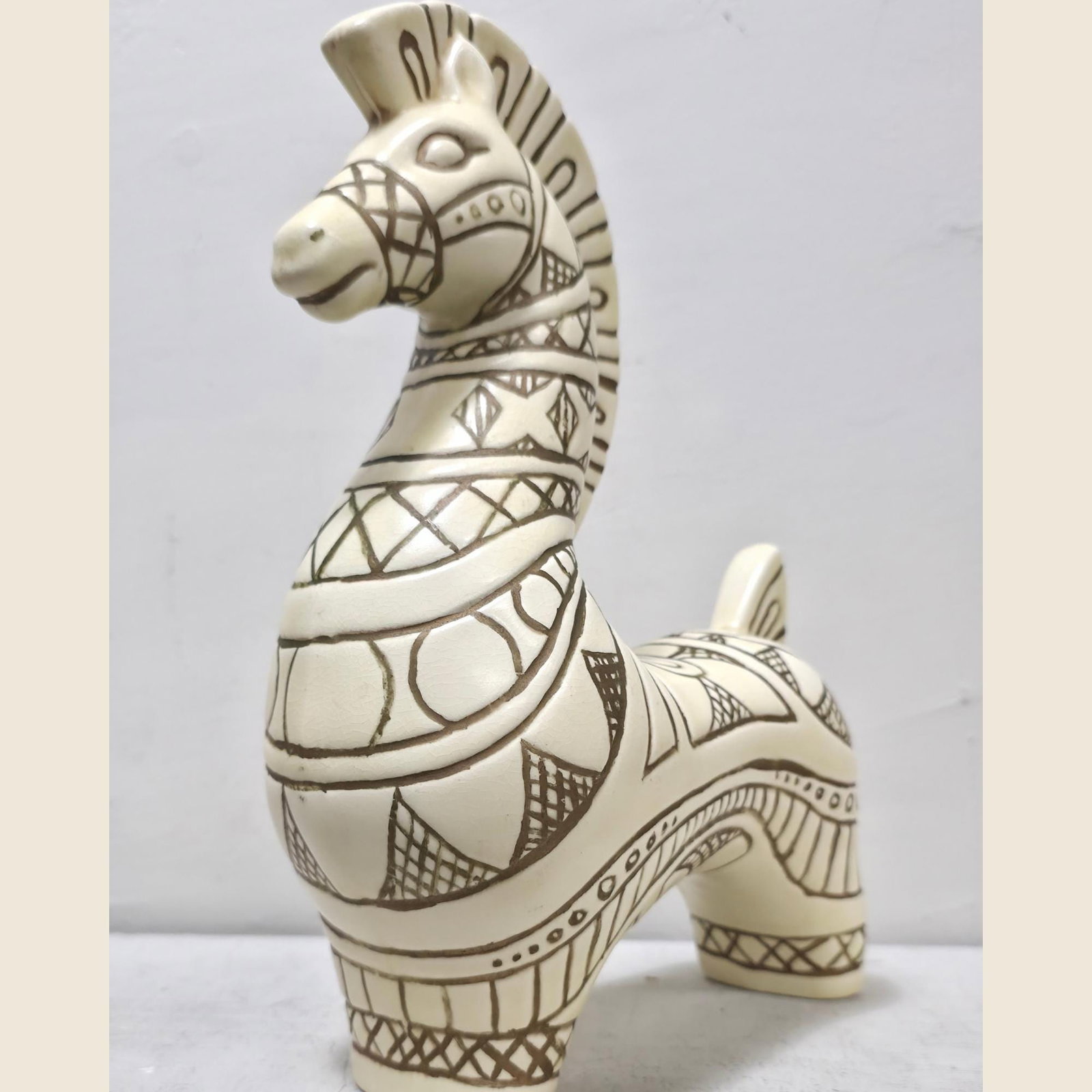 Studio Ceramic Horse Sculpture, Sgraffito Incised Geometric Decor, Signed 1967: Hand-carved by a studio artist in 1967, this ceramic horse carries the warm confidence of a piece made when the craft still mattered — bold incised geometry, a cream glaze warmed by brown, and