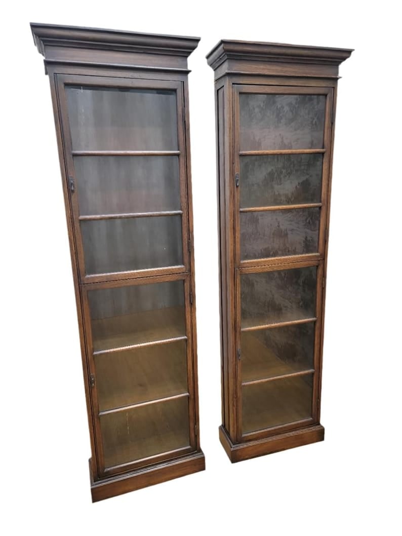 Antique Thai British Colonial Display Cabinet - Pair: Antique Thai British Colonial Teak and Glass Display Cabinet - Pair This british colonial tall and thin display cabinet has 5 shelves and 2 glass doors. Made of teakwood from Thailand these cabinets c