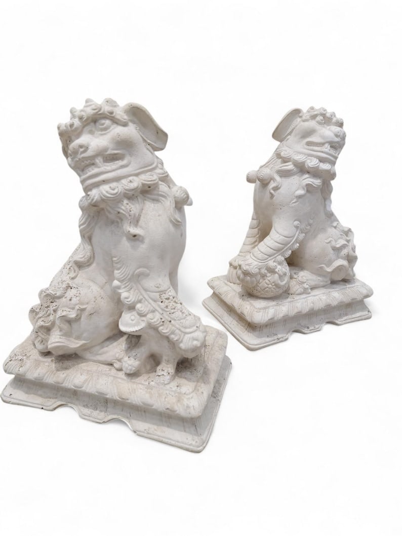 Vintage Asian Style Foo-Dog Statues - Pair: Vintage Asian Style Sculpted Resin Pedestal Mounted Foo-Dog Statues - Pair This pair of foo dog sculptures would be a distinctive accent piece in your space. Their neutral white coloring make them