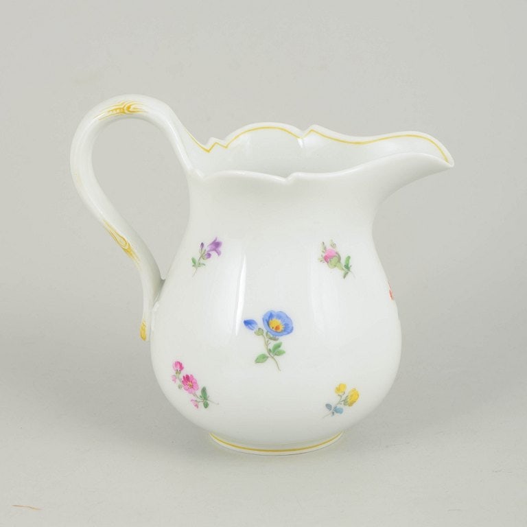 Meissen, Germany. Large porcelain creamer with polychrome flower decoration. Mid-20th century.: Meissen, large creamer with polychrome flower decoration. Large porcelain creamer hand painted with scattered polychrome flowers and a gilt rim. Elegant form with curved handle and scalloped edge, exe