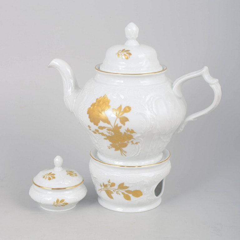 Rosenthal, Germany. Classic Rose porcelain teapot, heater/warmer, and sugar bowl with gilded rose: Rosenthal Classic Rose teapot, heater/warmer, and sugar bowl. Elegant porcelain service in white porcelain with relief decoration, gilded rose motifs, and gold trim. Comprising a large lidded teapot,