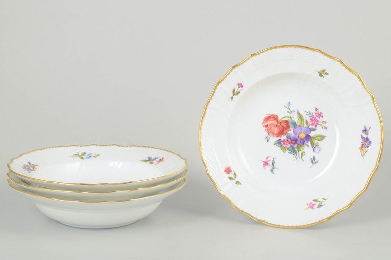 Royal Copenhagen, Denmark. Saxon flower, set of four porcelain deep plates with floral motifs.: Royal Copenhagen Saxon flower, set of four deep plates. Set of four deep porcelain plates decorated with hand-painted floral motifs in the Saxon flower pattern and finished with a gilded rim. Model 21